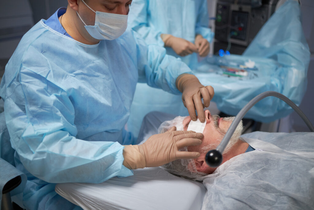 Middle Aged  Man Undergoing Eye Surgery Performed by Male Surgeon thumbnail
